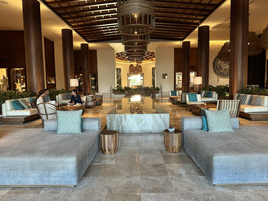 Large lobby with blue and white couches and brown column. 